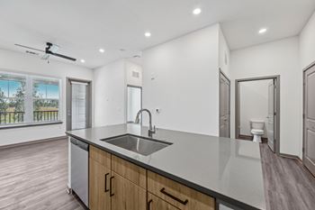 A modern kitchen with a large island and a fan. at The Concord Luxury Apartments, Sarasota, Florida
